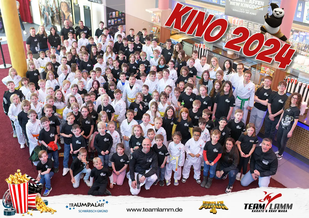 Großes Gruppenfoto der Kinder in Karateanzügen und Team-Shirts im Kinofoyer, Schriftzug Kino 2024