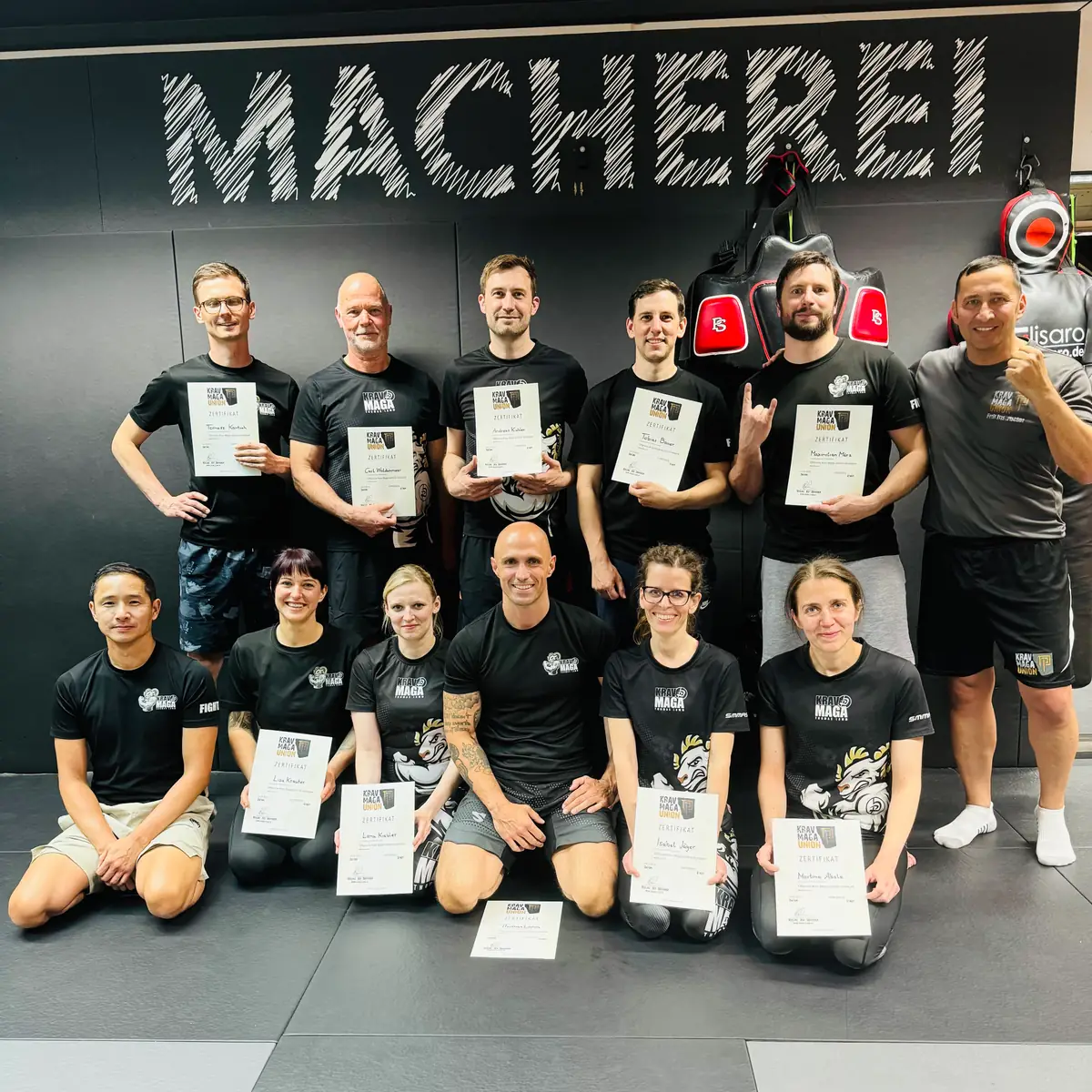 Gruppenfoto mit Teilnahmeurkunden vor der Wand der Kraftmacherei
