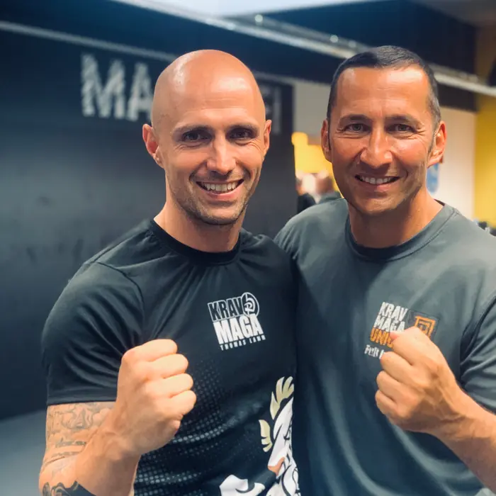 Thomas Lamm im Krav-Maga-Shirt neben einem Trainingspartner