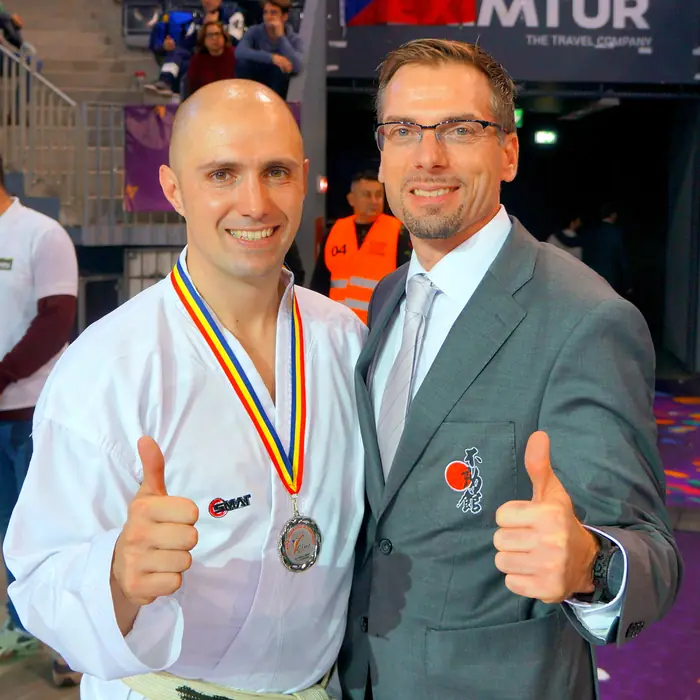 Thomas Lamm mit Medaille und Daumen hoch neben einem Begleiter
