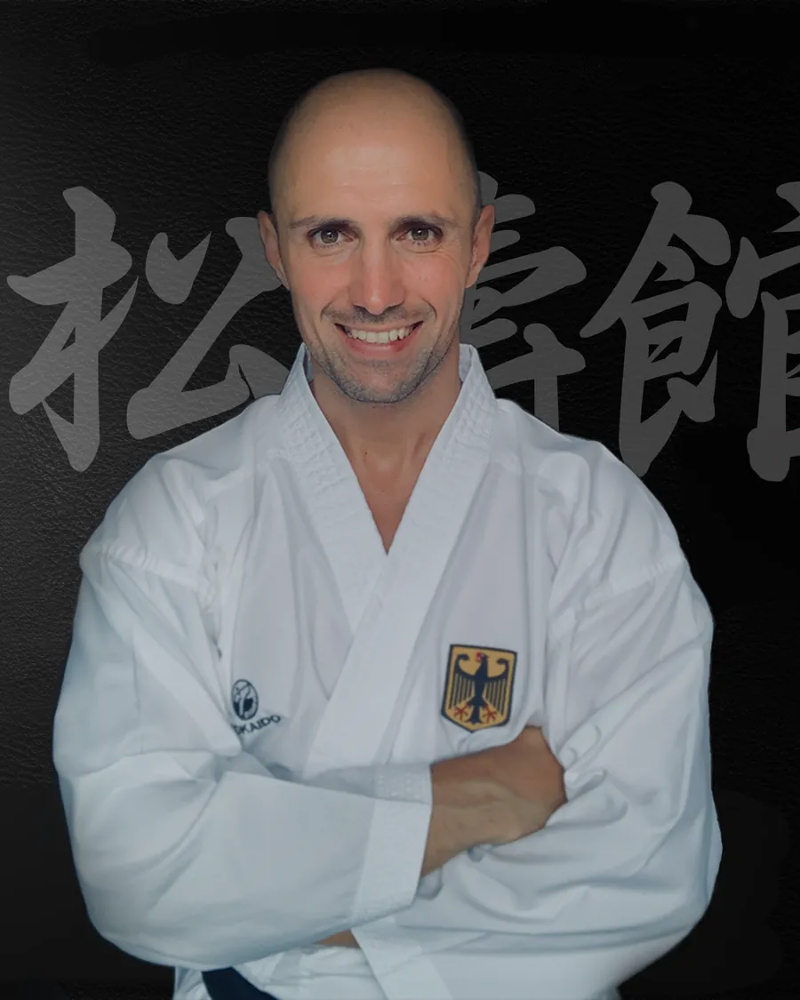 Thomas Lamm, Inhaber von TEAM LAMM, im Karateanzug mit verschränkten Armen